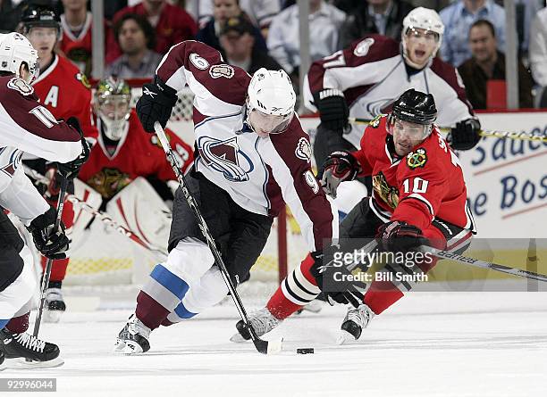 Matt Duchene of the Colorado Avalanche and Patrick Sharp of the Chicago Blackhawks chase after the puck on November 11, 2009 at the United Center in...