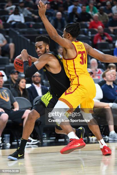 Oregon forward Troy Brown is closely defended by USC guard Elijah Stewart during the semifinal game of the mens Pac-12 Tournament between the Oregon...