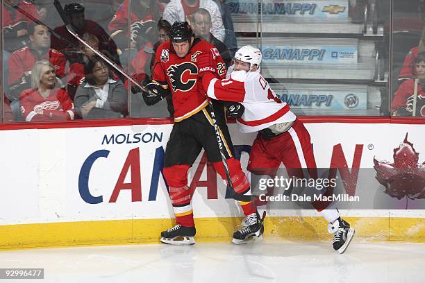 Daniel Cleary of the Detroit Red Wings checks Robyn Regehr of the Calgary Flames during their game on October 31, 2009 at the Pengrowth Saddledome in...