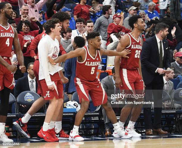 The Alabama bench reacts as the team takes a big second half lead during a Southeastern Conference Basketball Tournament game between Auburn and...