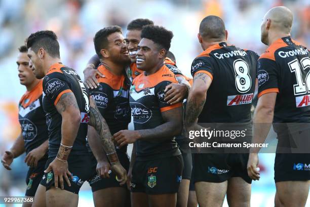 Tigers players celebrate winning the round one NRL match between the Wests Tigers and the Sydney Roosters at ANZ Stadium on March 10, 2018 in Sydney,...