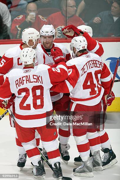 Daniel Cleary of the Detroit Red Wings, center, celebrates with teammates after a play during a break in game action against the Calgary Flames on...