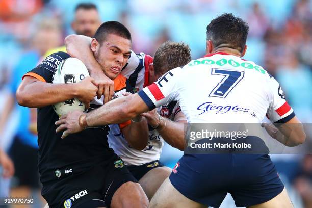 Tuimoala Lolohea of the Tigers is tackled during the round one NRL match between the Wests Tigers and the Sydney Roosters at ANZ Stadium on March 10,...
