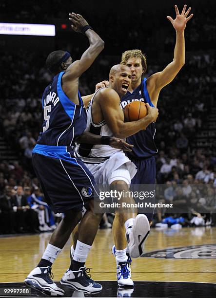 Richard Jefferson of the San Antonio Spurs drives to the basket against Josh Howard and Dirk Nowitzki of the Dallas Mavericks during the game at AT&T...