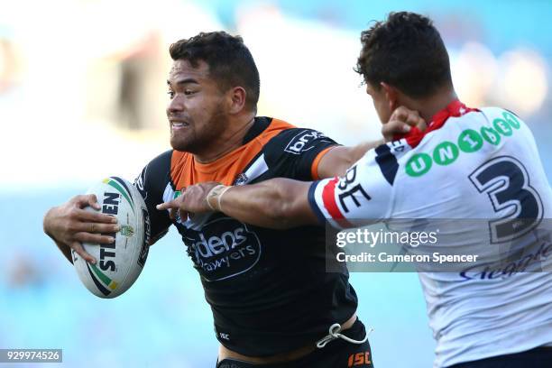 Esan Nike Marsters of the Tigers is tackled during the round one NRL match between the Wests Tigers and the Sydney Roosters at ANZ Stadium on March...