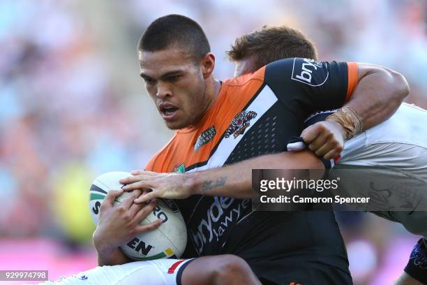 Tuimoala Lolohea of the Tigers is tackled during the round one NRL match between the Wests Tigers and the Sydney Roosters at ANZ Stadium on March 10,...