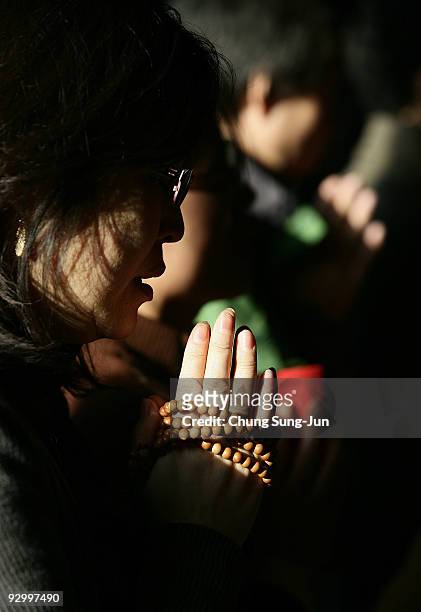 South Korean women pray for their childrens' success in the College Scholastic Ability Test at Chogye Buddhist temple on November 12, 2009 in Seoul,...