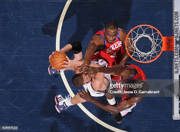 Brook Lopez of the New Jersey Nets shoots against Elton Brand and Samuel Dalembert of the Philadelphia 76ers during the game on November 11, 2009 at...