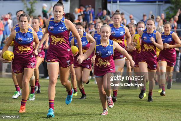 Lions run out for the start of the round six AFLW match between the Brisbane Lions and the Collingwood Magpies at Moreton Bay Sports Complex on March...