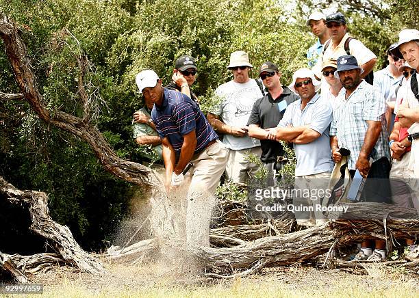 Tiger Woods of the USA chips out from the rough on the 9th hole during round one of the 2009 Australian Masters at Kingston Heath Golf Club on...