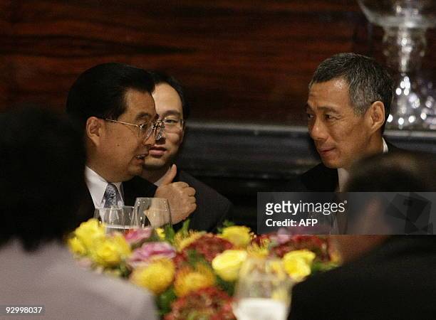 China's President Hu Jintao gestures during a lunch with Singapore's Prime Minister Lee Hsien Loong as part of his state visit during the...