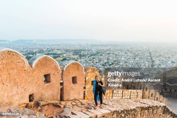 young woman discovers viewpoint from wall above city, jaipur - same person different looks stock pictures, royalty-free photos & images