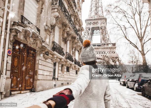 mujer caminando a la torre eiffel con nieve - paris france fotografías e imágenes de stock