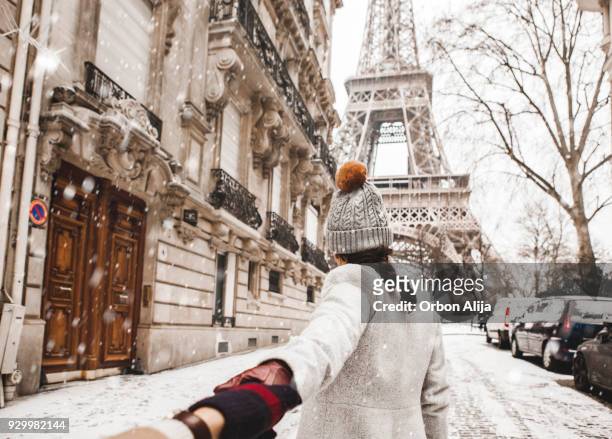 donna che cammina verso la torre eiffel con la neve - parigi foto e immagini stock