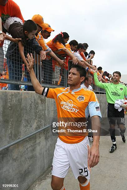 Brian Ching of the Houston Dynamo high fives fans while he walks down the ramp to the pitch before the Houston Dynamo play against the Seattle...
