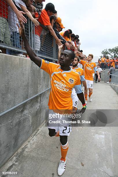 Dominic Oduro high fives fans while he walks down the ramp to the pitch before the Houston Dynamo play against the Seattle Sounders on November 8,...