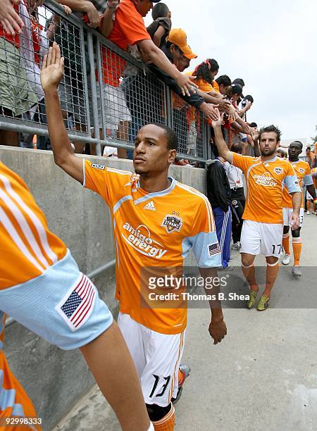 Ricardo Clark of the Houston Dynamo high fives fans while he walks down the ramp to the pitch before the Houston Dynamo play against the Seattle...