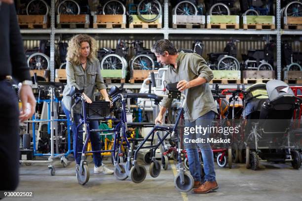 full length of mature workers examining equipment at warehouse - tool rack ストックフォトと画像