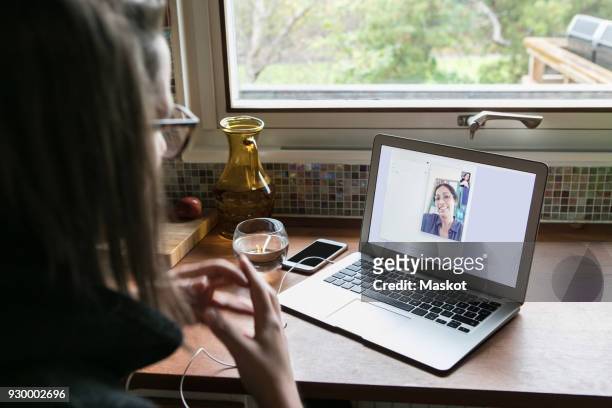High angle view of businesswoman video calling female colleague on laptop in home office
