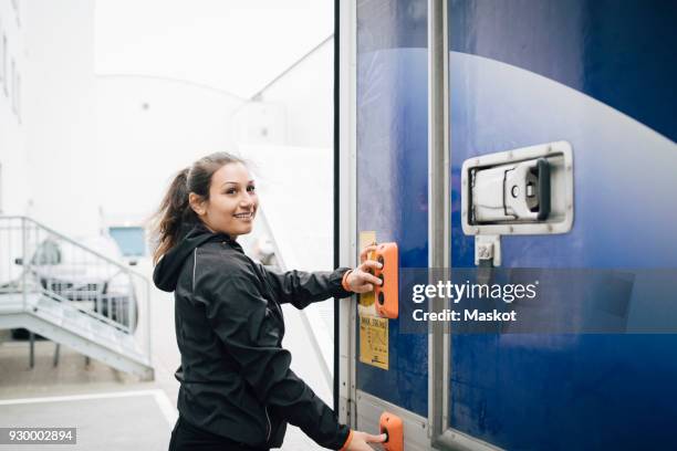 smiling woman pushing buttons on delivery van - unloading stock-fotos und bilder