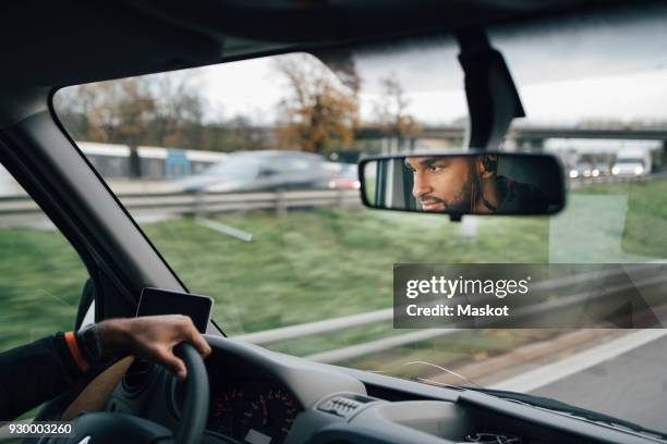 man is reflecting on rear-view mirror of delivery van - rear view mirror stock pictures, royalty-free photos & images