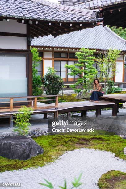 blick auf frau am handy im zen-garten von chion-ji-tempel in kyoto, japan - kumikomini stock-fotos und bilder