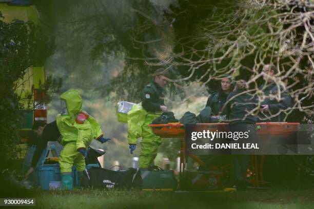 Members of the emergency services don their green biohazard suits as they prepare to work at the London Road Cemetery in Salisbury, southern England,...