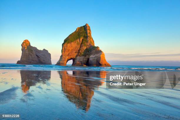 archway islands at wharariki beach,cape farewell, tasman, new zealand - kahurangi national park fotografías e imágenes de stock