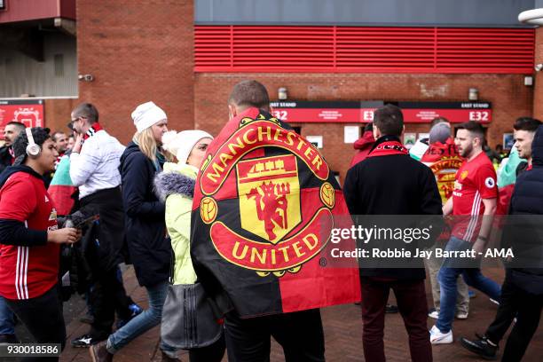 Fan of Manchester Untied draped in a Manchester Untied flag prior to the UEFA Champions League Round of 16 Second Leg match between Manchester City...