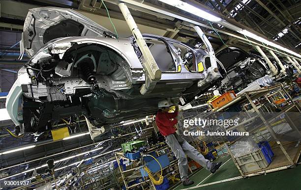 Workers assemble parts at Nissan's Tochigi Plant as Nissan anounce the opening of the latest FUGA motor car production line on November 12, 2009 in...