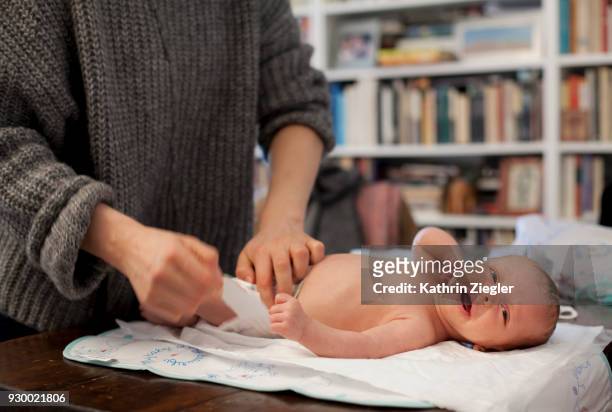 baby boy being changed by his mother and not liking it - changing nappy stock pictures, royalty-free photos & images