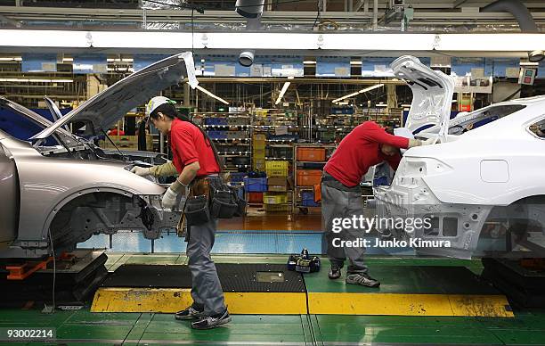 Workers assemble parts at Nissan's Tochigi Plant as Nissan announce the opening of the latest FUGA motor car production line on November 12, 2009 in...