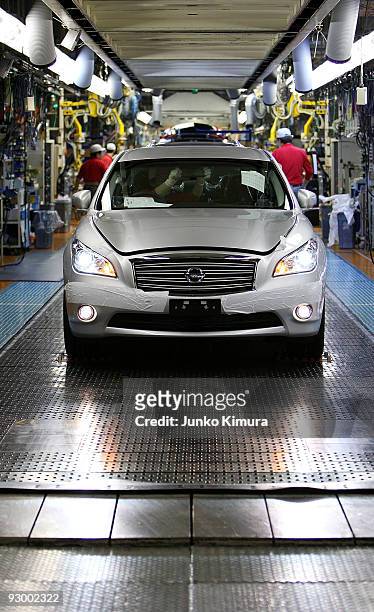 Workers check the assembled cars at Nissan's Tochigi Plant as Nissan announce the opening of the latest FUGA motor car production line on November...