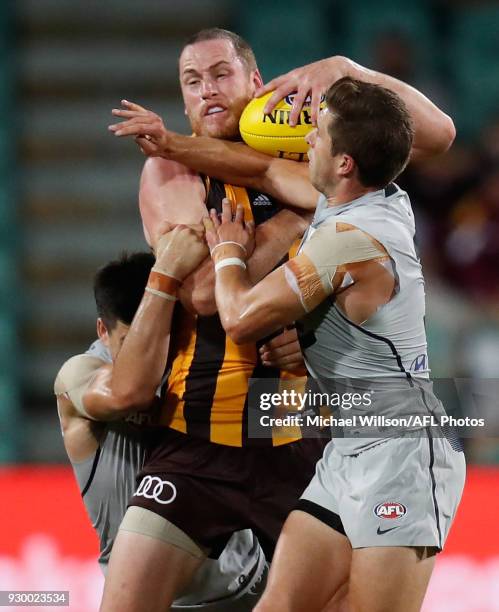 Jarryd Roughead of the Hawks is tackled by Matthew Kennedy and Marc Murphy of the Blues during the AFL 2018 JLT Community Series match between the...