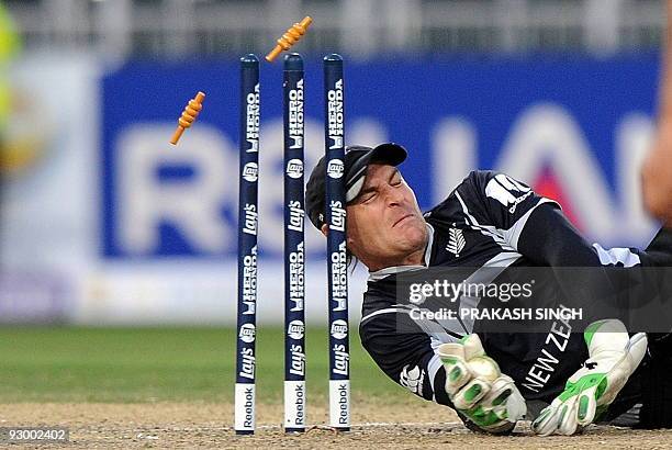 New Zealand's wicket keeper Brendon McCullum collides with stumps in an attempt to run out a Pakistan's batsman during the ICC Champions Trophy's...