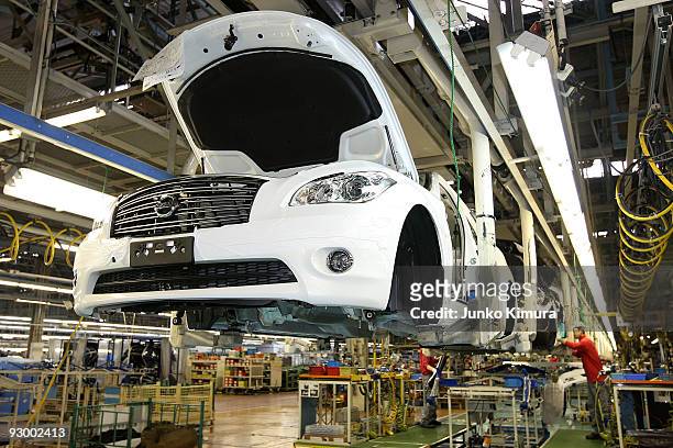 Workers assemble parts at Nissan's Tochigi Plant as Nissan announce the opening of the latest FUGA motor car production line on November 12, 2009 in...