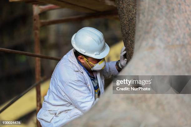 Egyptian workers restore a giant granite statue of the ancient Egyptian Pharaoh Ramses II at the Atrium of the Grand Egyptian Museum , near the...