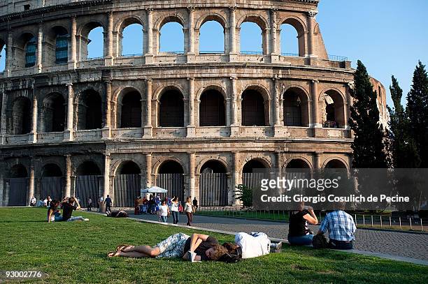 Tourists resting in the lawn in front of the Coliseum, in the centre of town on July 27, 2009 in Rome, Italy. Every year around 15 milions of...