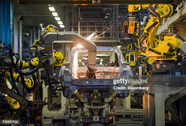 Robots work on the body of a vehicle at Nissan Motor Co.'s Tochigi plant in Tochigi Prefecture, Japan, on Thursday, Nov. 12, 2009. A stronger yen...