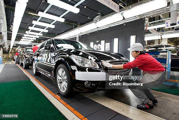 Worker makes final checks to a Fuga vehicle at Nissan Motor Co.'s Tochigi plant in Tochigi Prefecture, Japan, on Thursday, Nov. 12, 2009. A stronger...