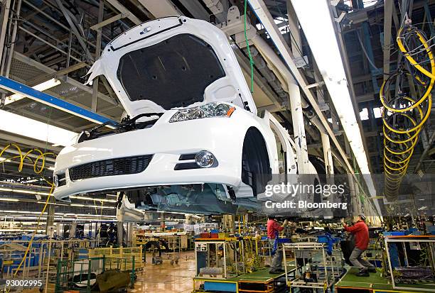 Workers assemble parts onto a vehicle at Nissan Motor Co.'s Tochigi plant in Tochigi Prefecture, Japan, on Thursday, Nov. 12, 2009. A stronger yen...
