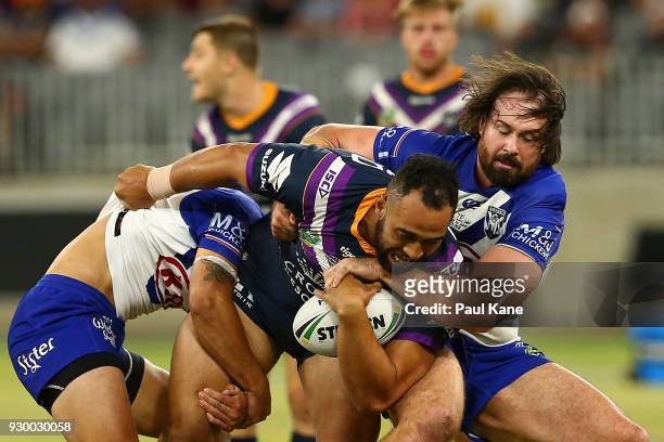 Aaron Woods of the Bulldogs tackles Sam Kasiano of the Storm during the round one NRL match between the Canterbury Bulldogs and the Melbourne Storm...