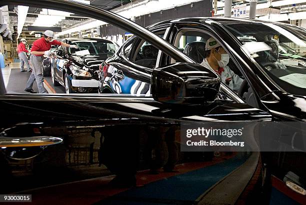 Workers make final inspections of vehicles at Nissan Motor Co.'s Tochigi plant in Tochigi Prefecture, Japan, on Thursday, Nov. 12, 2009. A stronger...