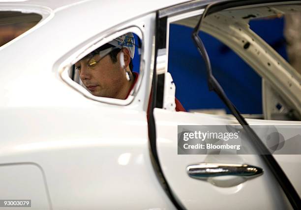 Worker assembles a vehicle at Nissan Motor Co.'s Tochigi plant in Tochigi Prefecture, Japan, on Thursday, Nov. 12, 2009. A stronger yen would be a...