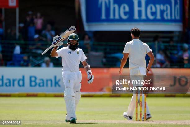 South Africa's batsman, Hashim Amla raises his bat to celebrate scoring a half-century during day two of the second Sunfoil Cricket Test match...