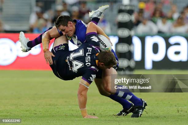 Tim Glasby of the Storm is tackled by Josh Jackson of the Bulldogs during the round one NRL match between the Canterbury Bulldogs and the Melbourne...