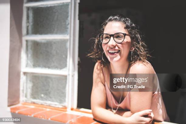 ragazza che guarda attraverso la finestra - persona di casa foto e immagini stock