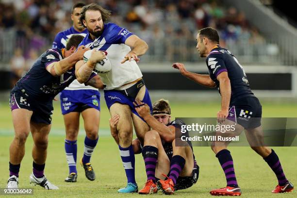 Aaron Woods of the Bulldogs is tackled during the round one NRL match between the Canterbury Bulldogs and the Melbourne Storm at Perth Stadium on...