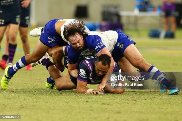 Aaron Woods of the Bulldogs tackles Sam Kasiano of the Storm during the round one NRL match between the Canterbury Bulldogs and the Melbourne Storm...