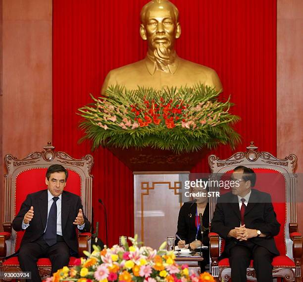 Visiting French Prime Minister Francois Fillon gestures as he speaks with Vietnamese Communist Party Secretary General Nong Duc Manh while they sit...